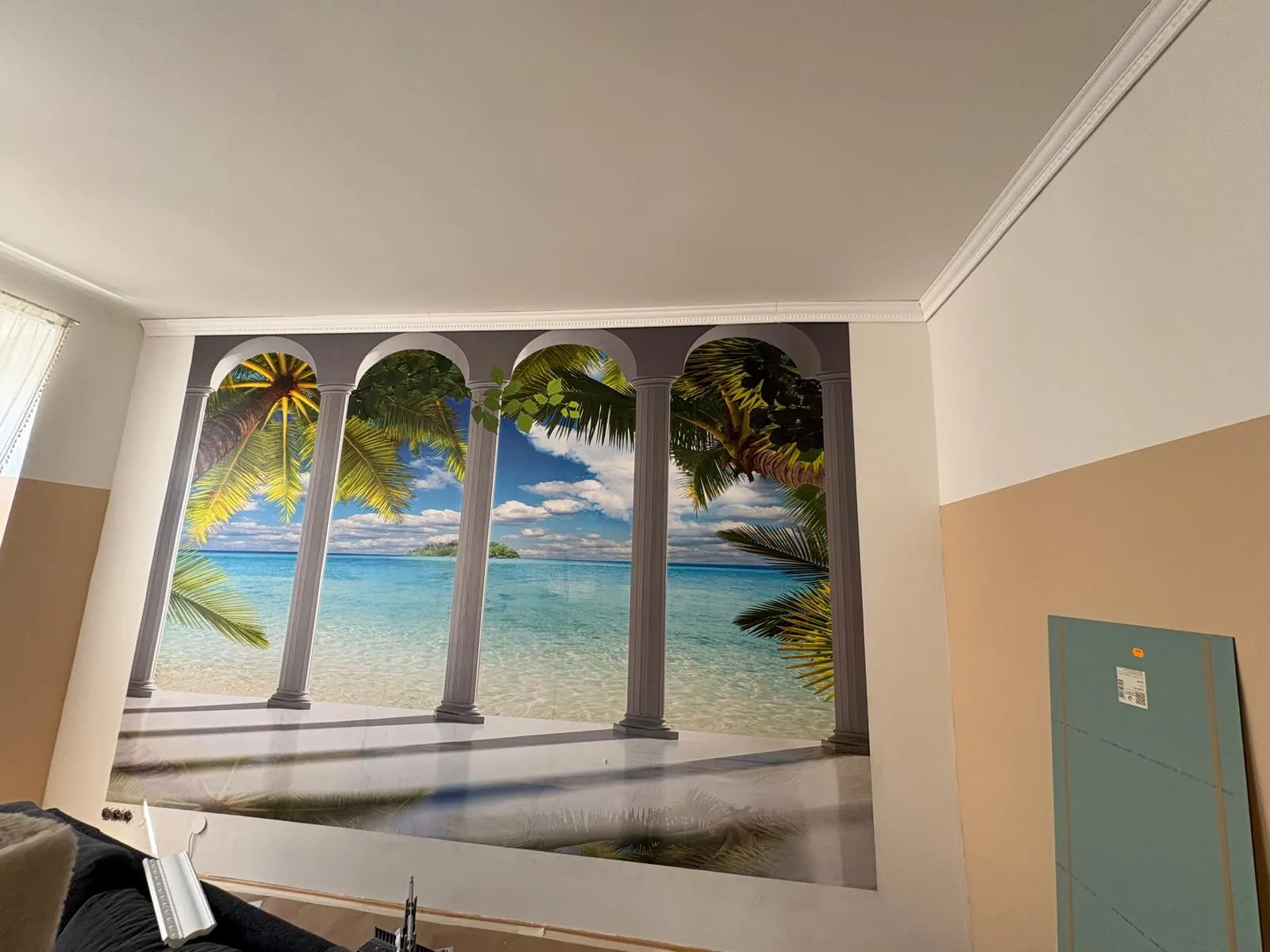 Fototapete mit Säulen und Strandmotiv an einer Wohnzimmerwand