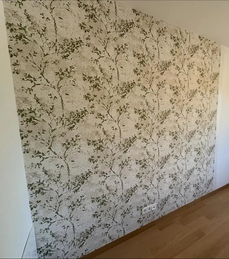 Wand mit Tapete mit grünem Pflanzenmuster
